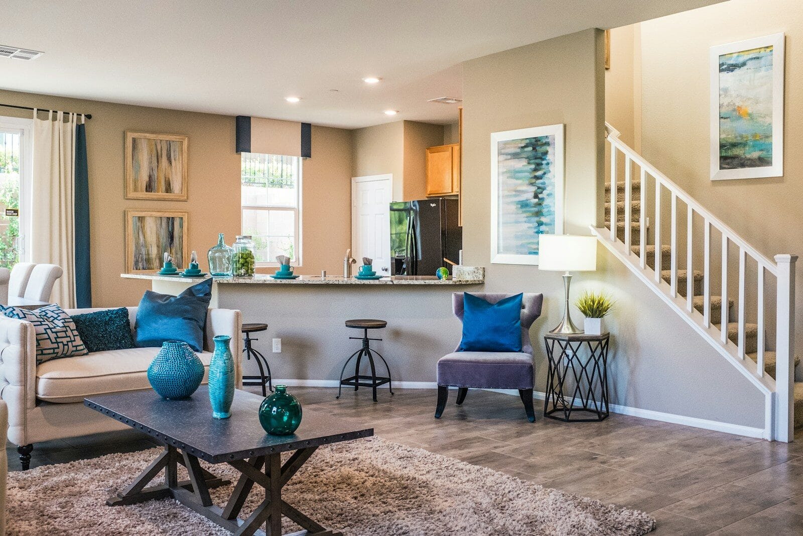 A living room with a sofa, coffee table, and open kitchen area