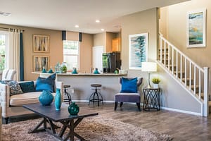 A living room with a sofa, coffee table, and open kitchen area
